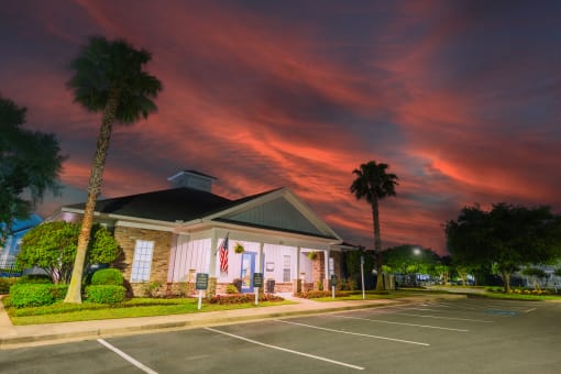 the front of our building at sunset with palm trees