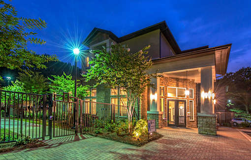 A house with a lit up driveway and a gate.