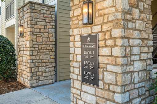 A sign on a stone pillar indicates the building number and the number of floors.