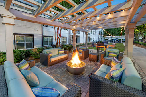A patio with a fire pit and seating area.