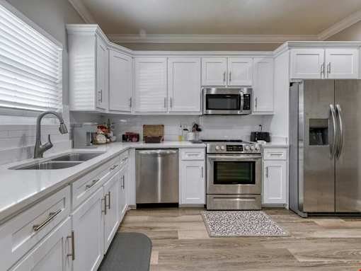 A kitchen with white cabinets and stainless steel appliances.