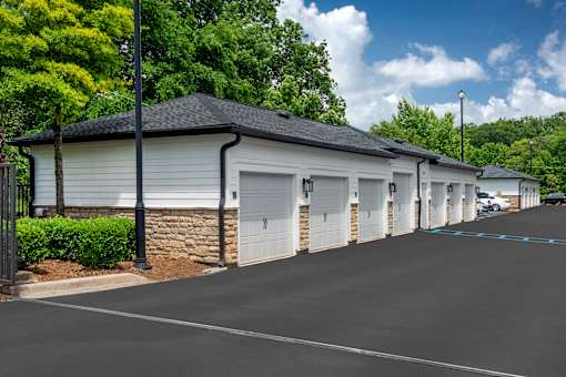 A long row of garages with trees in the background.