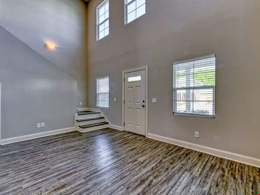 A room with wooden flooring and a white door.
