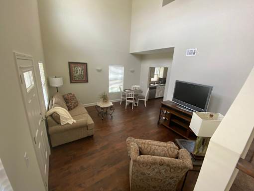 A living room with a couch, chairs, and a television.