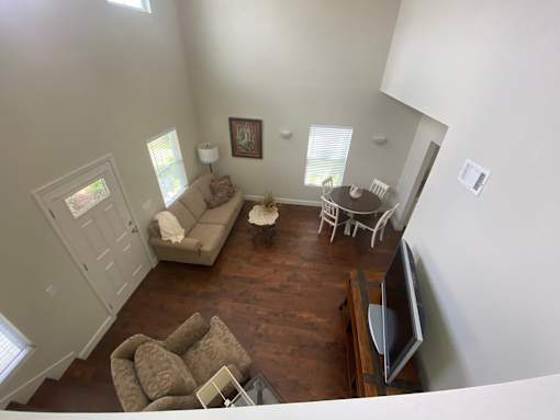 A living room with a couch, chairs, and a television.
