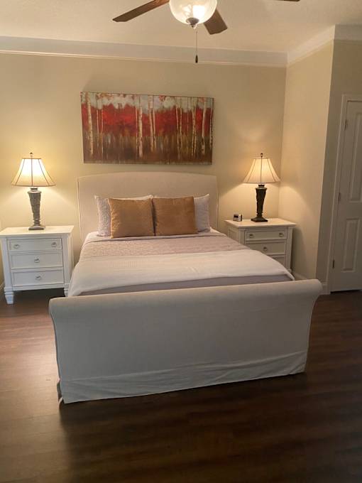 A bedroom with a large bed and two lamps.