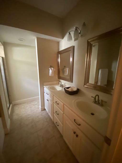 A bathroom with a sink, mirror, and cabinets.