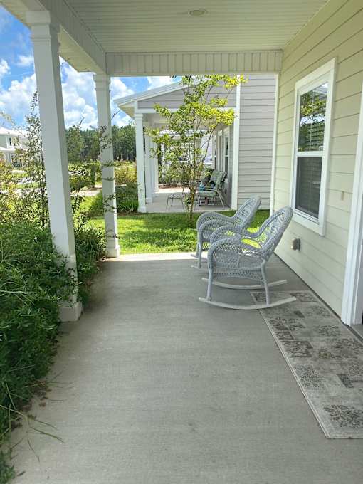 A porch with a rocking chair and a table.
