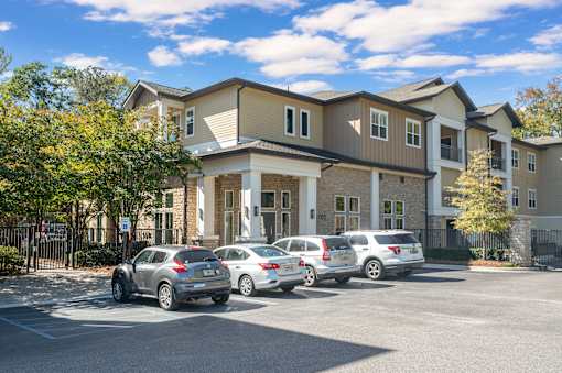 A row of cars are parked in front of a building.