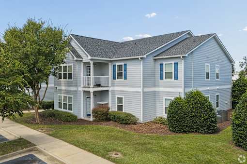 A two-story house with a grey exterior and blue trim.