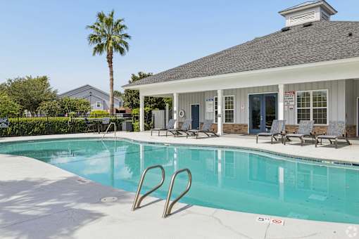 A pool with a building behind it.