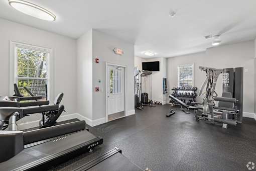 A spacious gym with treadmills, weights, and exercise equipment.