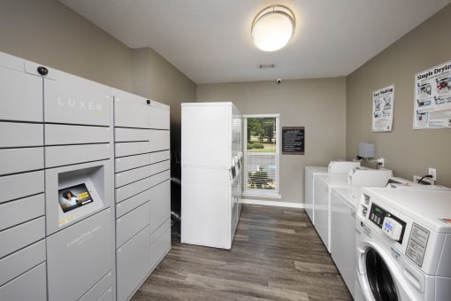 a laundry room with washer and dryers and a window