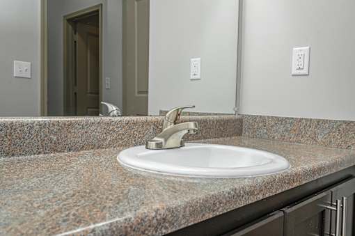A bathroom sink with a granite counter top.