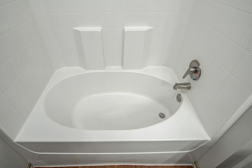 A white bathtub with a silver faucet and a silver handle.