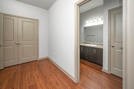 A room with a wooden floor and a mirror on the wall.