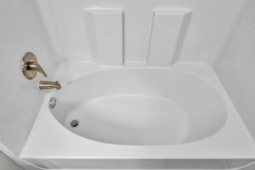 A white toilet with a gold flush handle.