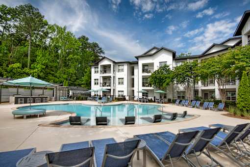 A large white building with a pool in front.