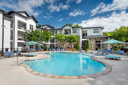 A swimming pool in front of apartment buildings.