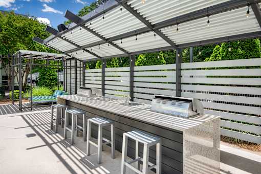 A row of stools are lined up under a roof.