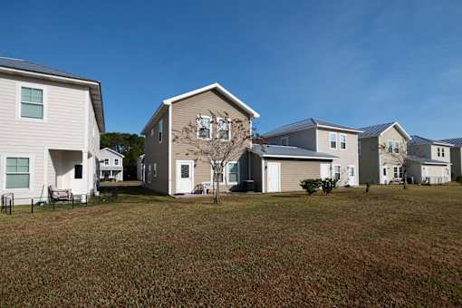 A row of houses with a tree in front of the middle house.