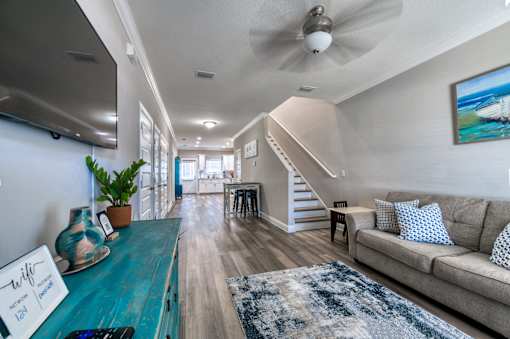 A living room with a blue couch and a rug.