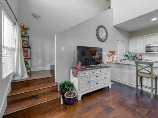 A kitchen with a wooden floor and a clock on the wall.