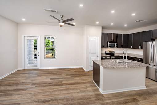 A kitchen with a large island and a ceiling fan.
