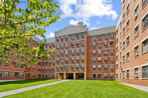 a large brick building with a grassy area in front of it