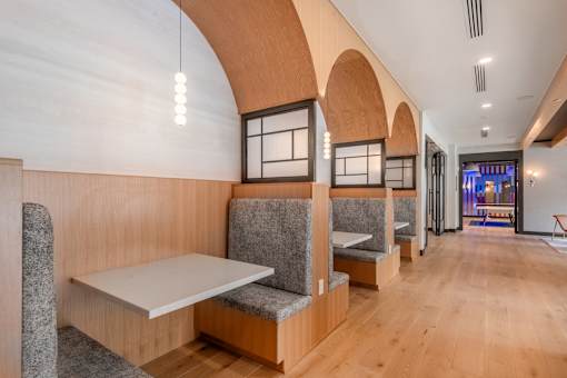 A long hallway with benches and tables on the side.