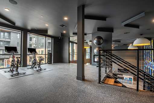 A room with a grey carpet and a black railing.