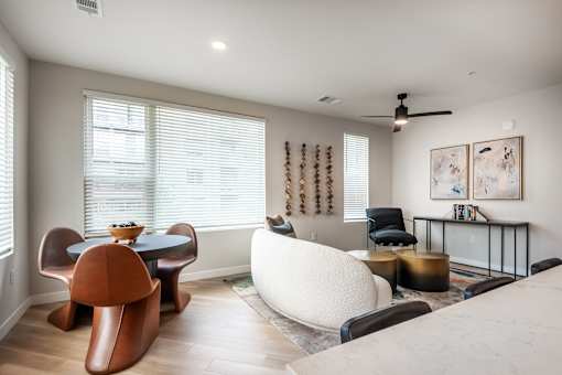 A living room with a brown chair and a white sofa.