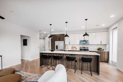 A modern kitchen with a bar area and a dining table.