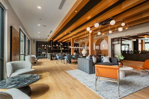 A modern living room with a wooden ceiling and furniture.