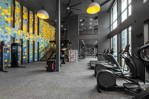 A gym with treadmills and a staircase.