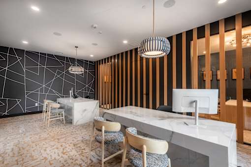 A modern office space with a white marble desk and wooden chairs.