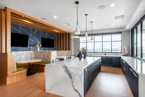 A modern kitchen with a marble island and wooden accents.