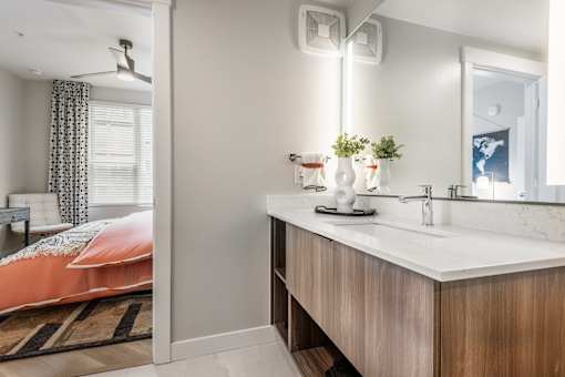 A bathroom with a bedroom area visible through the open door.