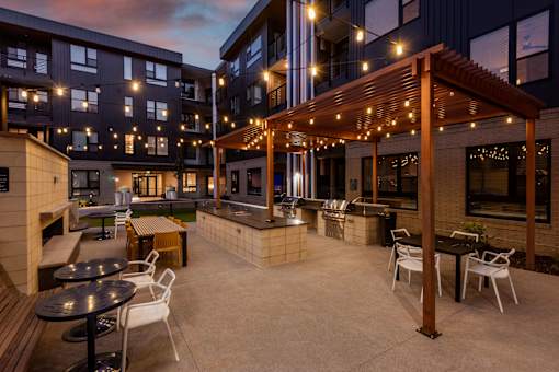 A patio area with tables and chairs under a pergola.