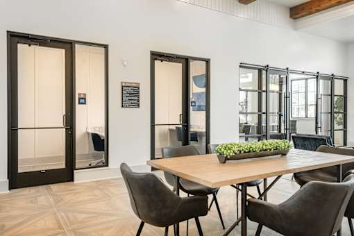A dining room with a table and chairs and a glass door.
