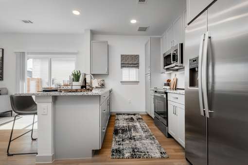 A modern kitchen with a large island and stainless steel appliances.