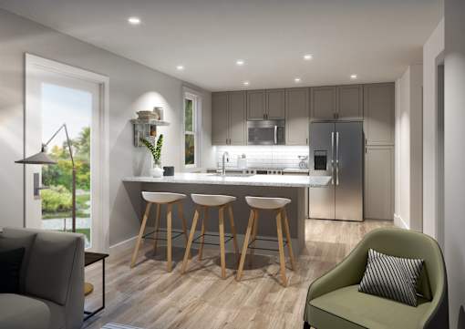 A modern kitchen with a bar stool and a green armchair.