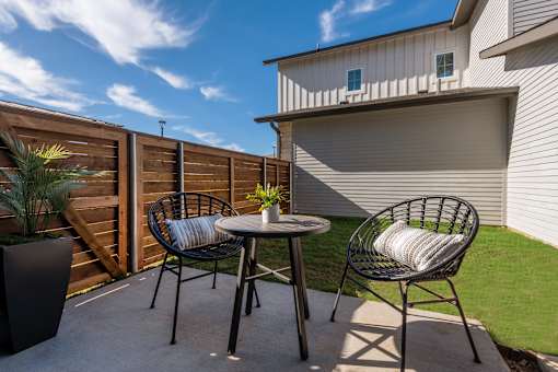 A patio with a table and two chairs.