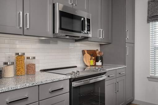 A modern kitchen with a stainless steel oven and microwave.
