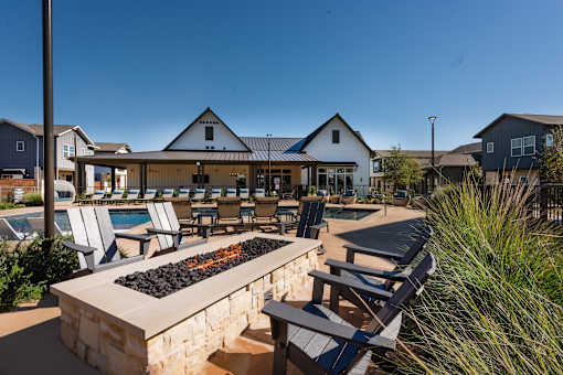 A poolside area with chairs and a fire pit.
