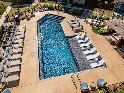 A large outdoor swimming pool surrounded by sun loungers.