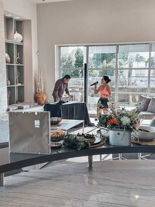 a man and woman standing in a living room with a table with food on it