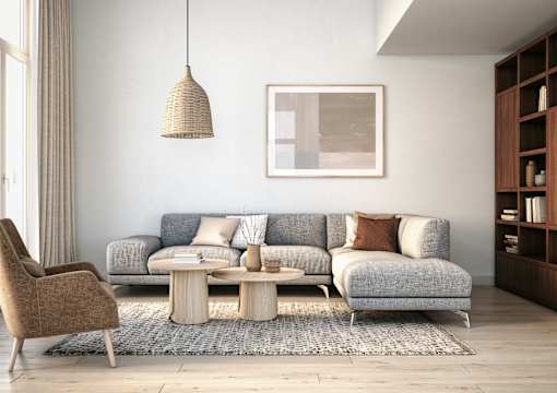 A living room with a grey couch, a brown chair, and a wooden coffee table.