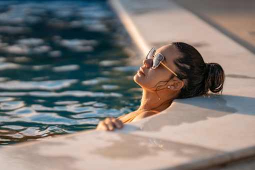 A woman in sunglasses is relaxing in a pool.