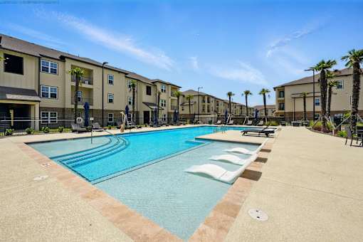A large swimming pool in front of apartment buildings. at Beau Chene Lake Charles Apartments, Lake Charles